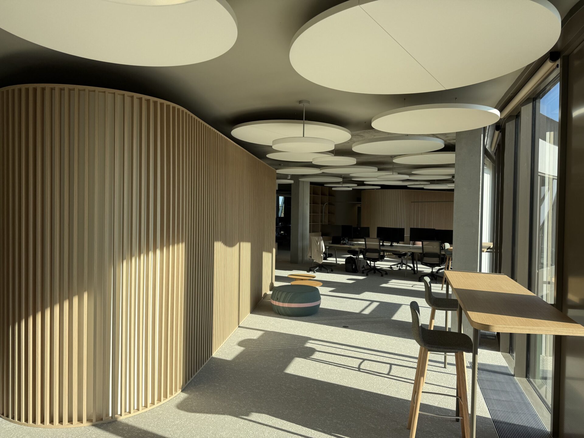 Open space avec divers réalisations sur-mesure dont cloison claire-voie et tablette de travail.